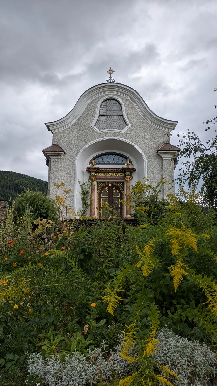 Small white chapel on a green hillside