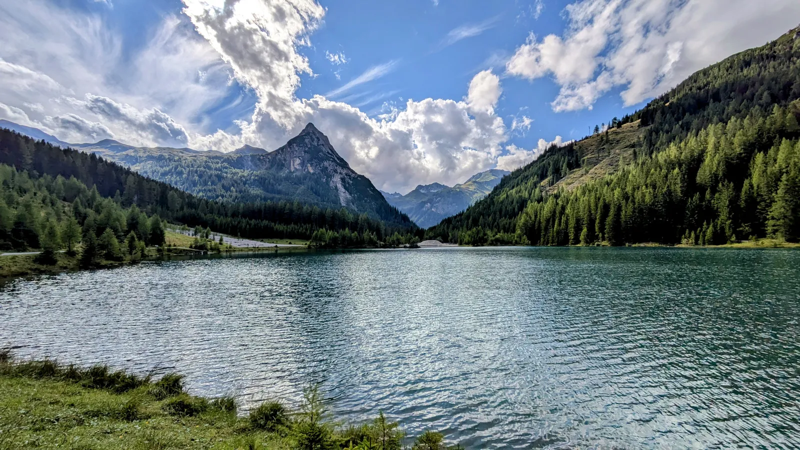 Wide mountain lake framed by forest and peaks