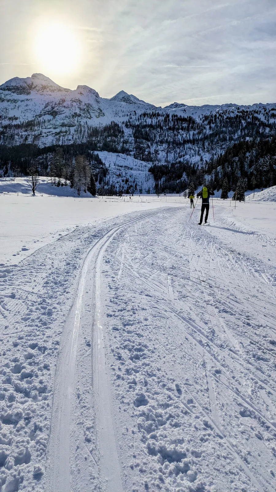 Snow tracks leading toward a bright mountain horizon